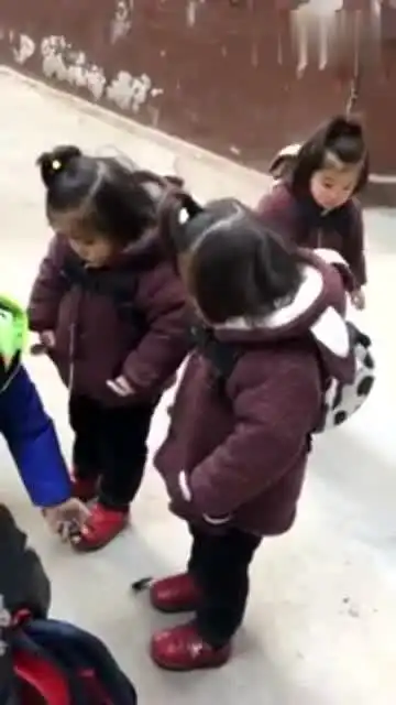  三胞胎宝宝在路边看人玩游戏,表情神同步