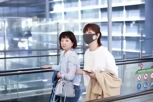  徐静蕾婆媳俩走机场显卑微穿得像跟班,主动挽手婆婆表情不善良