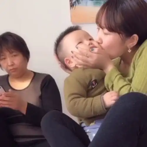  妈妈亲自己的儿子,不知道婆婆在后面为什么这个表情